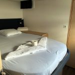 Cabine avant du catamaran Fountaine Pajot Saba 50 avec lit double, hublots panoramiques et confort haut de gamme pour une croisière aux Grenadines.