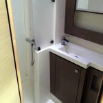 Salle de bain du catamaran Fountaine Pajot avec douche, lavabo et rangements pour un confort optimal en croisière aux Grenadines.
