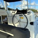 Poste de barre du catamaran Lagoon 40 avec commandes ergonomiques et vue panoramique pour naviguer aux Grenadines.