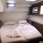 Cabine arrière du catamaran Lagoon 450 avec lit double, rangements et hublots pour une croisière confortable aux Grenadines.