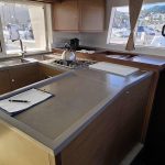 Cuisine du catamaran Lagoon 450 entièrement équipée avec plan de travail spacieux pour une croisière confortable aux Grenadines.