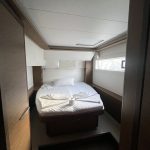 Cabine arrière du catamaran Lagoon 46 avec lit double, rangements et hublots panoramiques pour une croisière aux Grenadines.