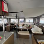 Carré du catamaran Lagoon 46 avec salon panoramique lumineux et espace de vie élégant pour une croisière aux Grenadines.