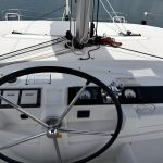 Poste de barre du catamaran Lagoon 46 avec barre à roue, instruments de navigation et vue panoramique sur les Grenadines.